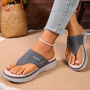 Vue détaillée des tongs compensées grises pour femmes avec surpiqûres blanches élégantes