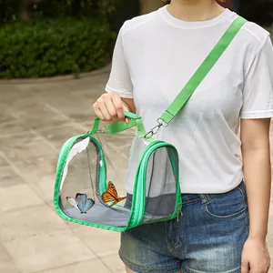 Detail of green transparent pet carrier bag with shoulder strap shown in use outdoors