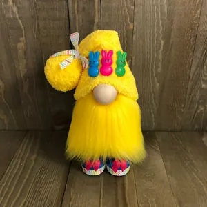 Vooraanzicht van een gele pluche paasgnome pop met konijntjes op een houten achtergrond