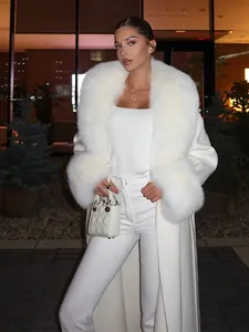 Detalle de un lujoso abrigo de invierno blanco con cuello de piel sintética y puños de pelo