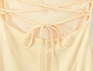 Close-up of the elegant lace-up back detail on a peach summer dress with zipper