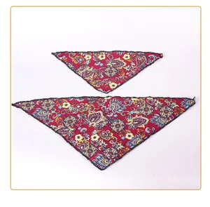 Detailed view of two pet bandanas featuring colorful paisley patterns on red fabric