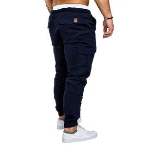 Detail view of men's navy blue cargo pants with back pockets and a tapered jogger fit.