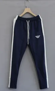 Close-up of navy blue men's joggers with white side stripes and tapered leg fit