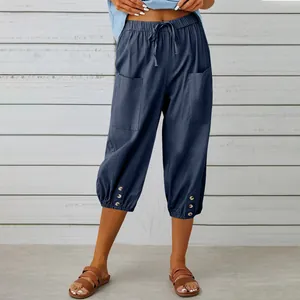 Close-up detail of blue linen cropped pants featuring drawstring waist and button cuffs