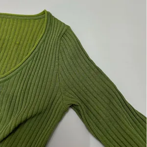 Detailed macro view showing the lime green ribbed knit fabric texture and shoulder seam