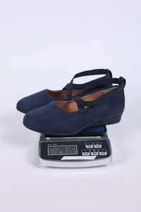 Vista macro que muestra el peso de estos zapatos de cuña de ante azul marino en báscula