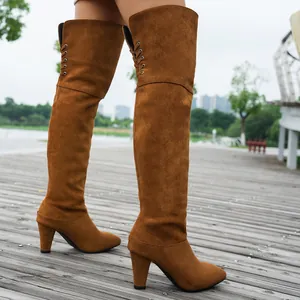Nahaufnahme brauner Overknee-Stiefel aus Wildleder mit Blockabsatz und Schnürdetails