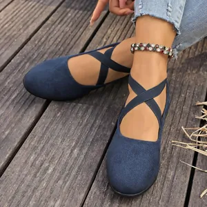 Primer plano detallado de ballerinas de ante azul con tiras cruzadas muy elásticas