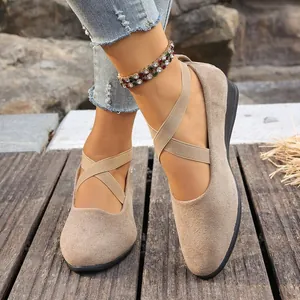 Vista detallada de zapatos de cuña en gamuza beige con correas cruzadas elásticas