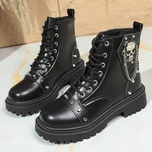 Détail de bottines noires pour hommes avec crâne punk et accents de chaîne