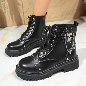Gros plan de bottines Martin noires de style punk avec crâne métallique et chaîne argentée