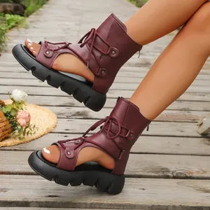 Detailansicht burgunderrote Gladiator-Sandalen mit Plateausohle auf Holzsteg