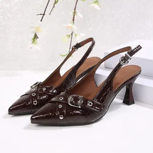 Detailed view of dark brown croc-embossed slingback heels with buckle straps