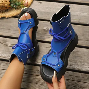 Detailansicht der blauen Plateausandalen mit Schnürung und modischem Lochmuster-Design.
