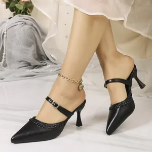Elegant French vintage black pointed toe mules featuring a stylish buckle strap detail.