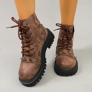 Détail de bottines de travail en cuir vieilli marron avec clous et semelle crantée