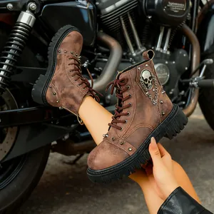 Gros plan sur des bottes de combat en cuir marron rétro avec tête de mort et chaîne