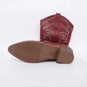 Detailweergave van de gestructureerde zool en het borduursel van de bordeauxrode cowboylaarzen.