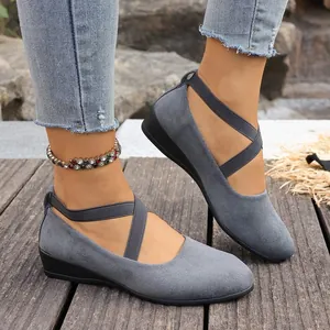Elegantes zapatos de cuña en ante gris con correas cruzadas y suela blanda cómoda
