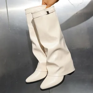 A detailed view of cream pleated knee-high pant leg boots featuring a top buckle strap.