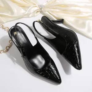 Close-up of elegant black crocodile embossed pointed-toe slingback high heel shoes