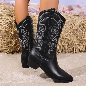 Gedetailleerd shot van zwarte western cowboylaarzen voor dames met wit bloemenborduursel
