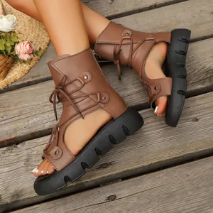 Nahaufnahme brauner Römersandalen zum Schnüren mit dicker Plateausohle und Cut-Out-Design