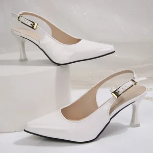 Detailed side view of white pointed-toe slingback heels with elegant buckle strap