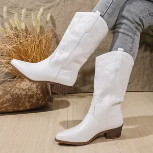 Detailopname van witte westernlaarzen met borduursels en elegante blokhakken