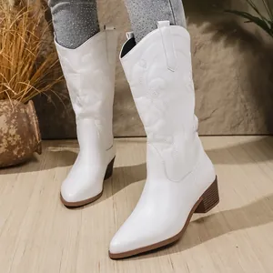 Detailweergave van witte western cowboylaarzen met stevige hak en geborduurde schacht.