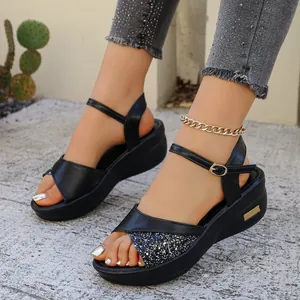 Detailopname van zwarte sleehaksandalen met glinsterende pailletten en bandjes