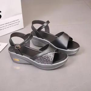 Detailweergave van grijze sleehaksandalen voor dames met glitterbandje en dikke plateauzool
