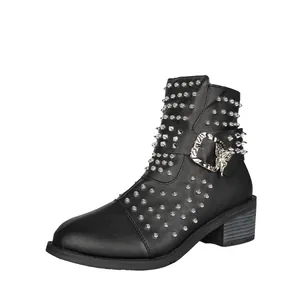 Gedetailleerd zijaanzicht van stijlvolle zwarte Chelsea-boots met studs en een vlindergesp