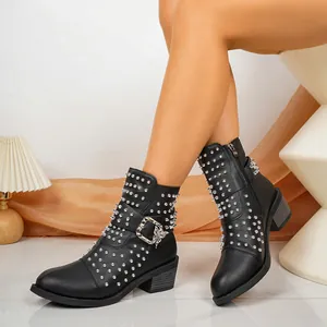 Detailweergave van zwarte leren enkellaarzen met zilveren studs en vlindergesp.