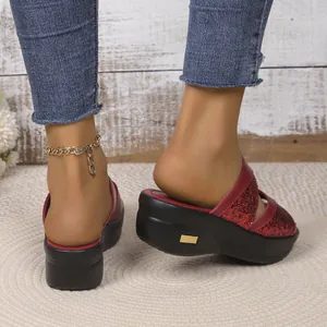 Detailopname van rode glitter sleehak sandalen met dikke platformzolen en goud.