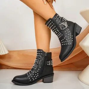 Gedetailleerd overzicht van zwarte punk enkellaarzen met zilveren studs en metalen gesp