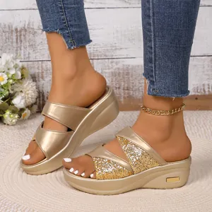 Detailopname van gouden platform sleehakken met glitterbandjes gedragen door een model