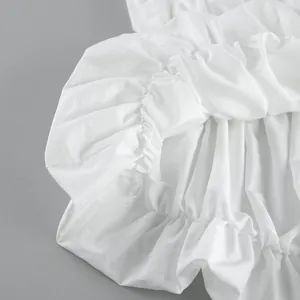 Close-up macro detail showing delicate ruffles and soft texture of a white summer tube top