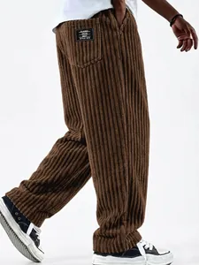 Detail of men's brown corduroy trousers showing textured fabric and pocket with logo label