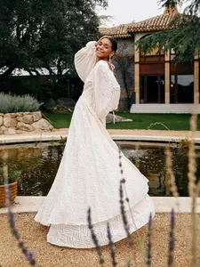 Elegant long-sleeved pleated jacquard white dress with lantern sleeves and a full skirt.