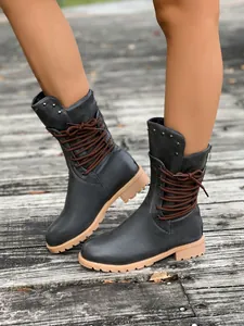 Detailansicht grauer Damen-Kurzstiefel im britischen Stil mit Nieten und braunen Schnürsenkeln