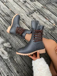 Detailansicht stilvoller grauer Stiefeletten im britischen Stil mit Nieten und Reißverschluss