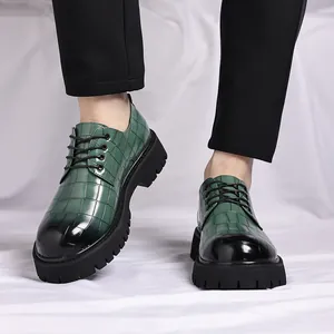 Dettaglio scarpe da uomo in pelle verde con motivo a coccodrillo e suola spessa