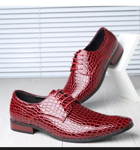 Detailansicht der glänzenden roten Herren-Schnürschuhe mit Krokoprägung im britischen Stil