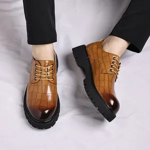 Primo piano di scarpe marroni da uomo con stampa coccodrillo e suole a carrarmato
