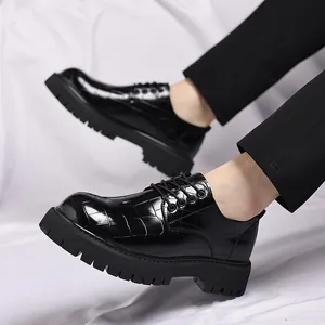 Primo piano di scarpe in pelle nera con motivo a coccodrillo e spessa suola a carrarmato