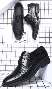 Nahaufnahme von schwarzen Herren-Anzugschuhen mit Webmuster und eleganten Brogue-Verzierungen.