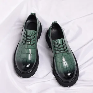 Detailweergave van modieuze herenleren schoenen met groen krokodillenpatroon verloop