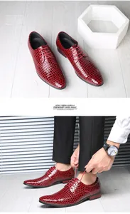Detailaufnahme von roten Herren-Oxford-Schuhen mit Krokodilprägung beim Binden durch Model